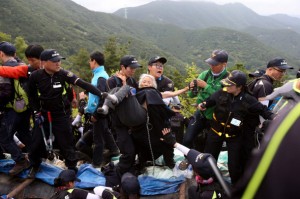 Several riot police carry away an elderly resident as a part of a sit-in site demolition operation in Miryang, June 11. (By Ryu Woo-jong, staff photographer)