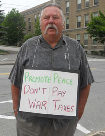 frank-sentencingday A man in a suit stands outside a federal courthouse on the day he is to report to federal prison as a war tax resister.